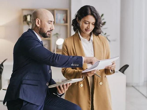 Professional male agent discussing paperwork with female client