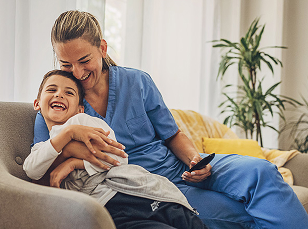 Female health professional hugging her child on couch